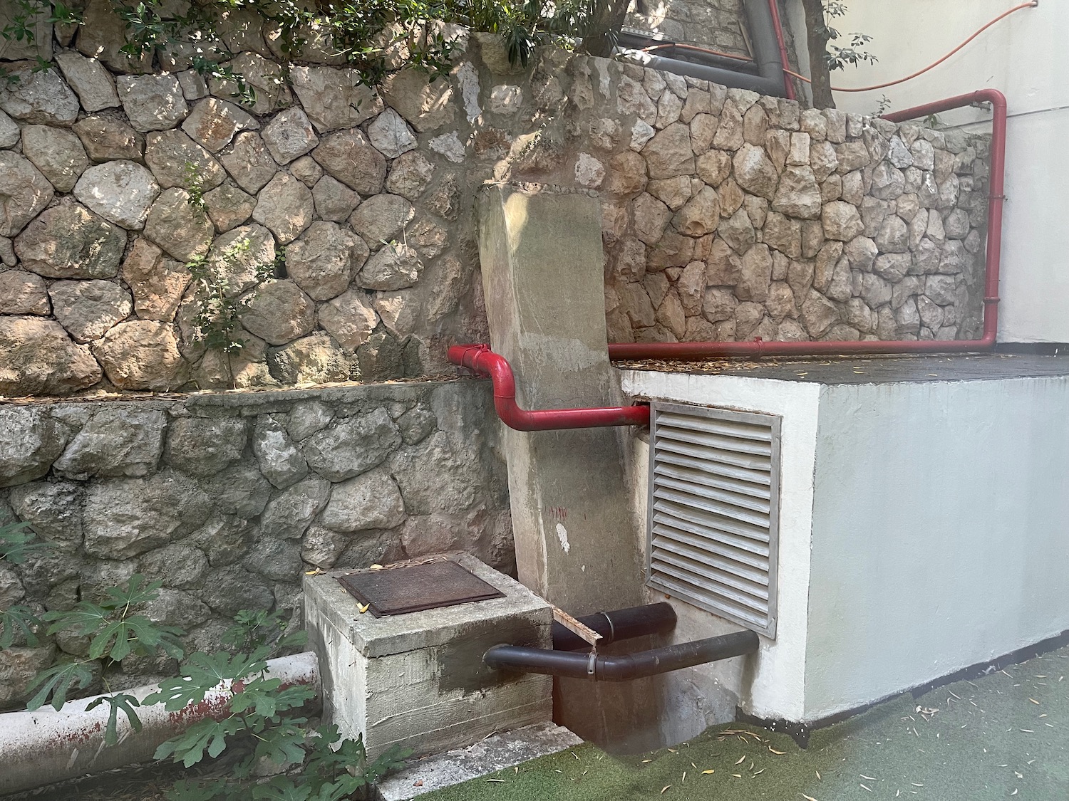 a concrete block with red pipes