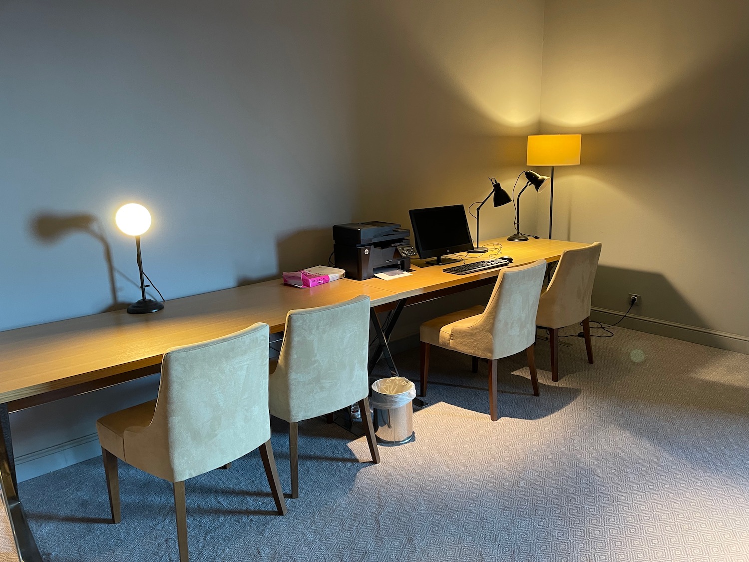 a desk with chairs and a computer