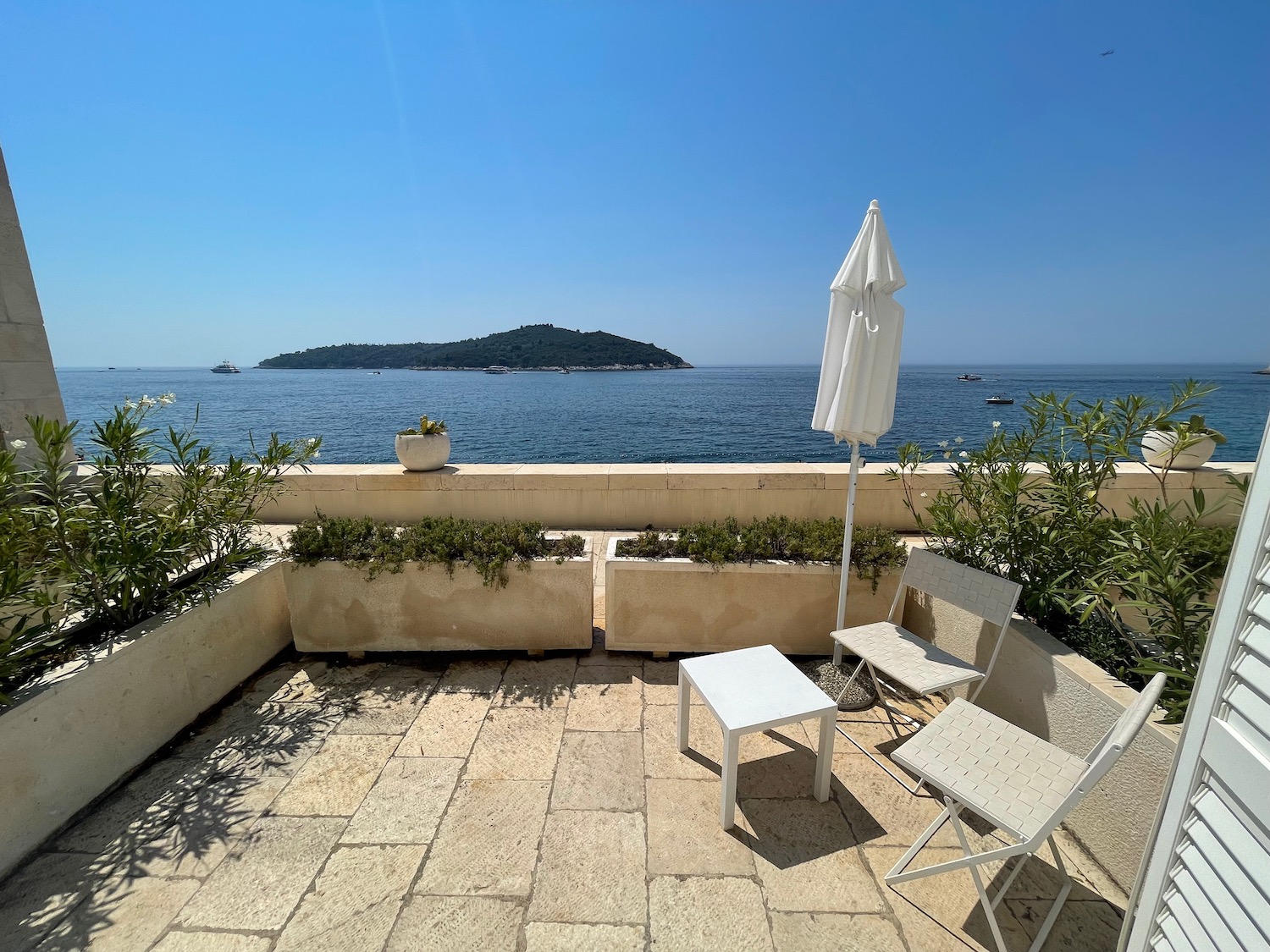 a patio with chairs and umbrella on a sunny day