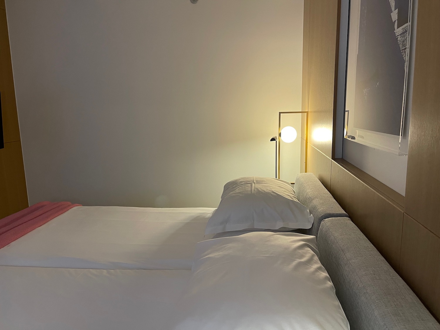 a bed with white sheets and a lamp