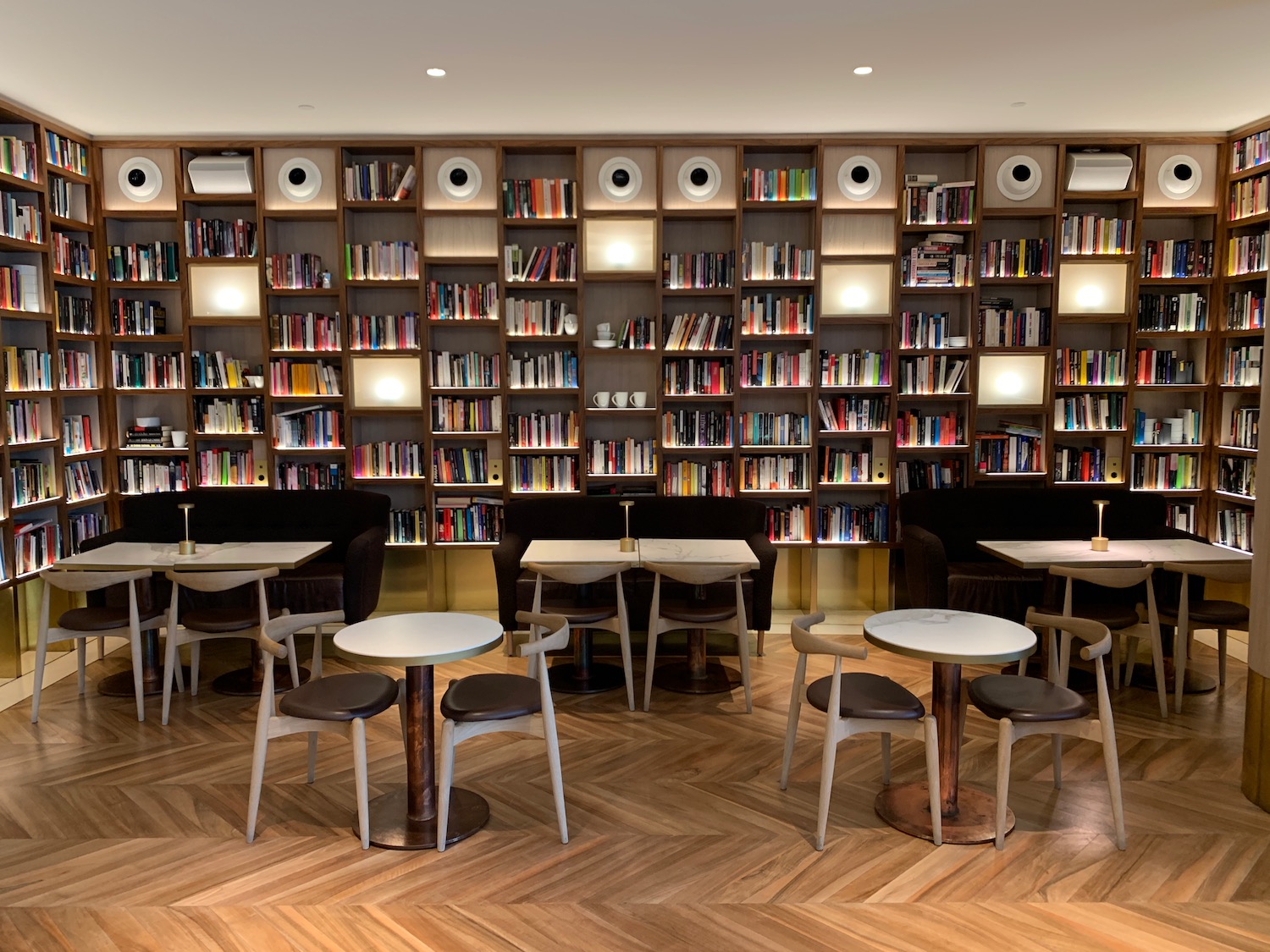 a room with tables and chairs and bookshelves