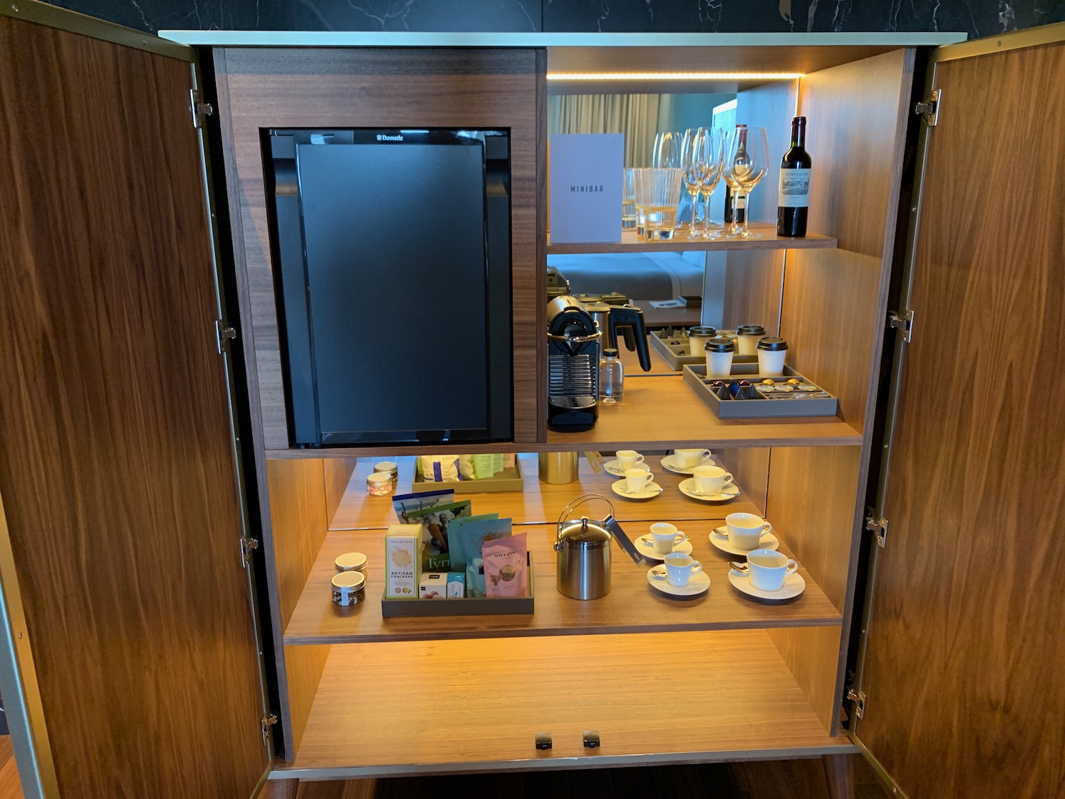 a cabinet with a tv and cups and glasses
