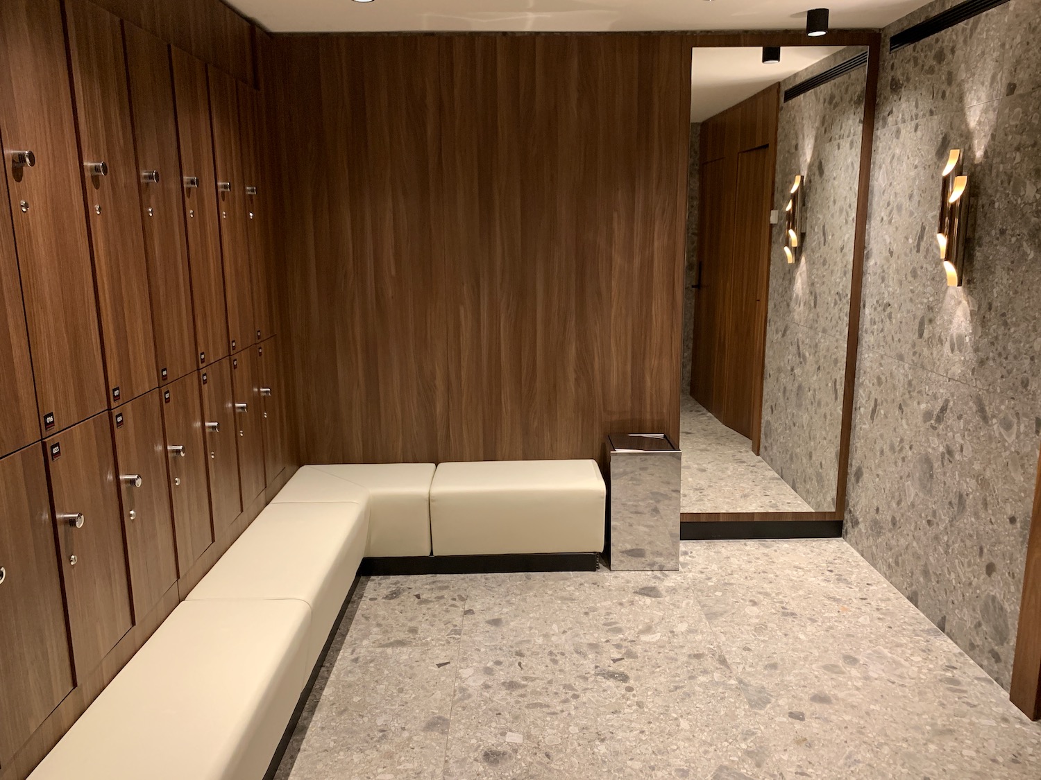 a locker room with white bench and lockers