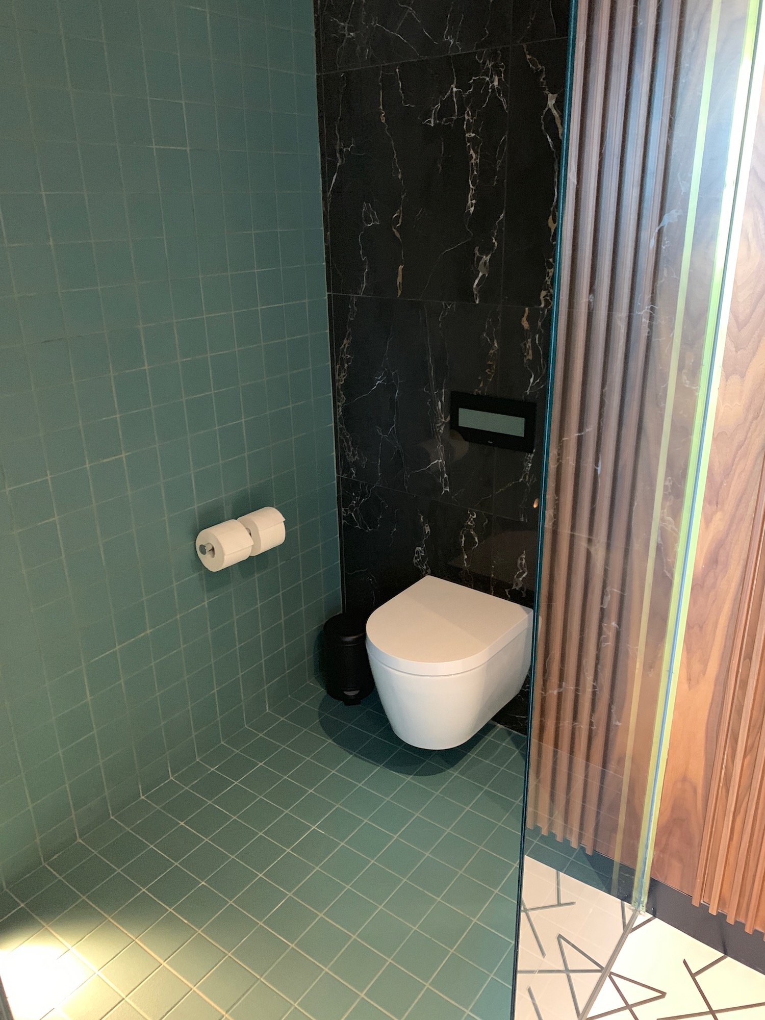 a bathroom with a toilet and a roll of toilet paper