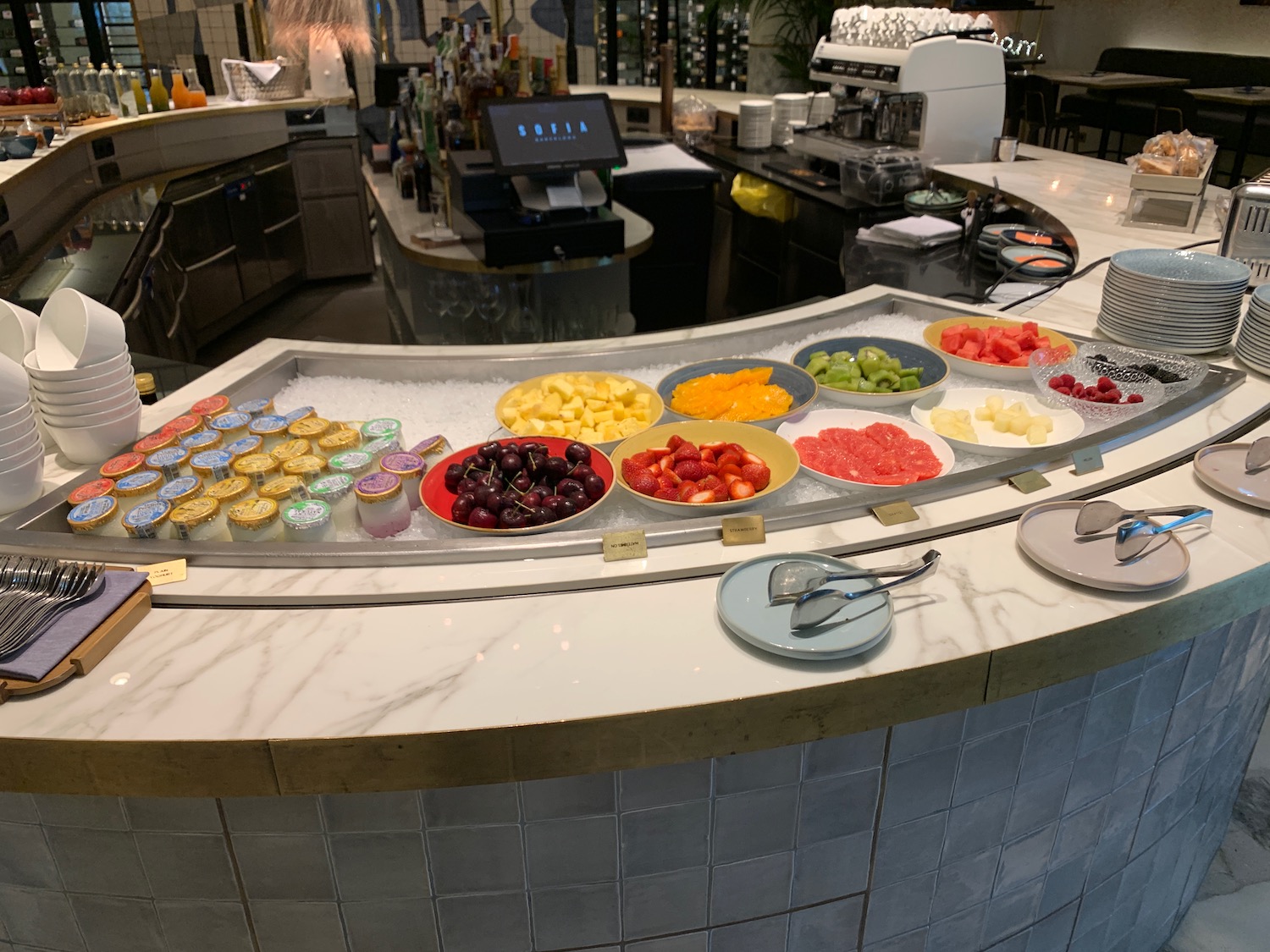 a counter with different colored bowls of fruit
