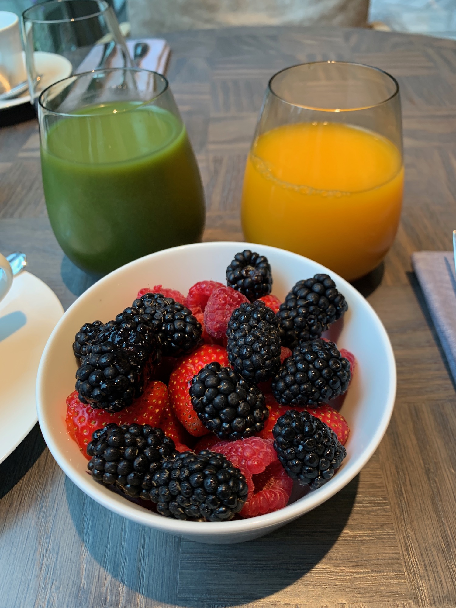 a bowl of berries and a drink