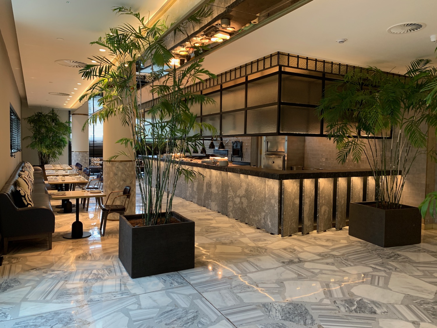 a restaurant with a large counter and plants