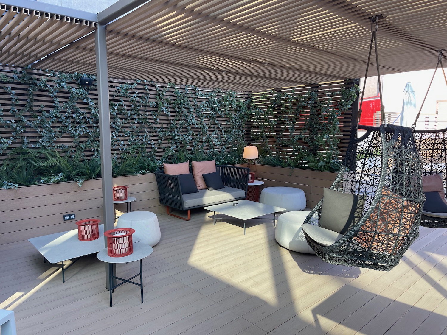 a patio with a swing chair and tables