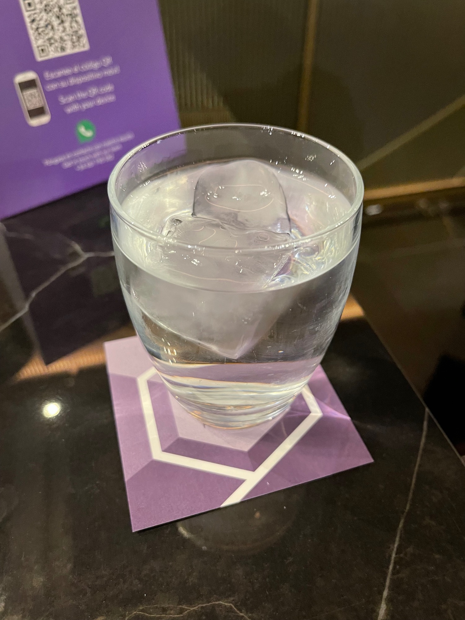 a glass of water with ice cubes on a table