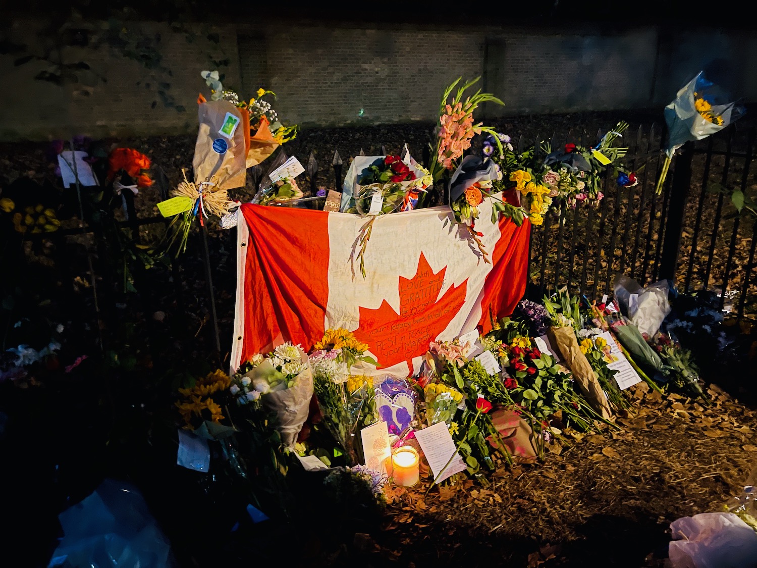 a flag and flowers on a fence