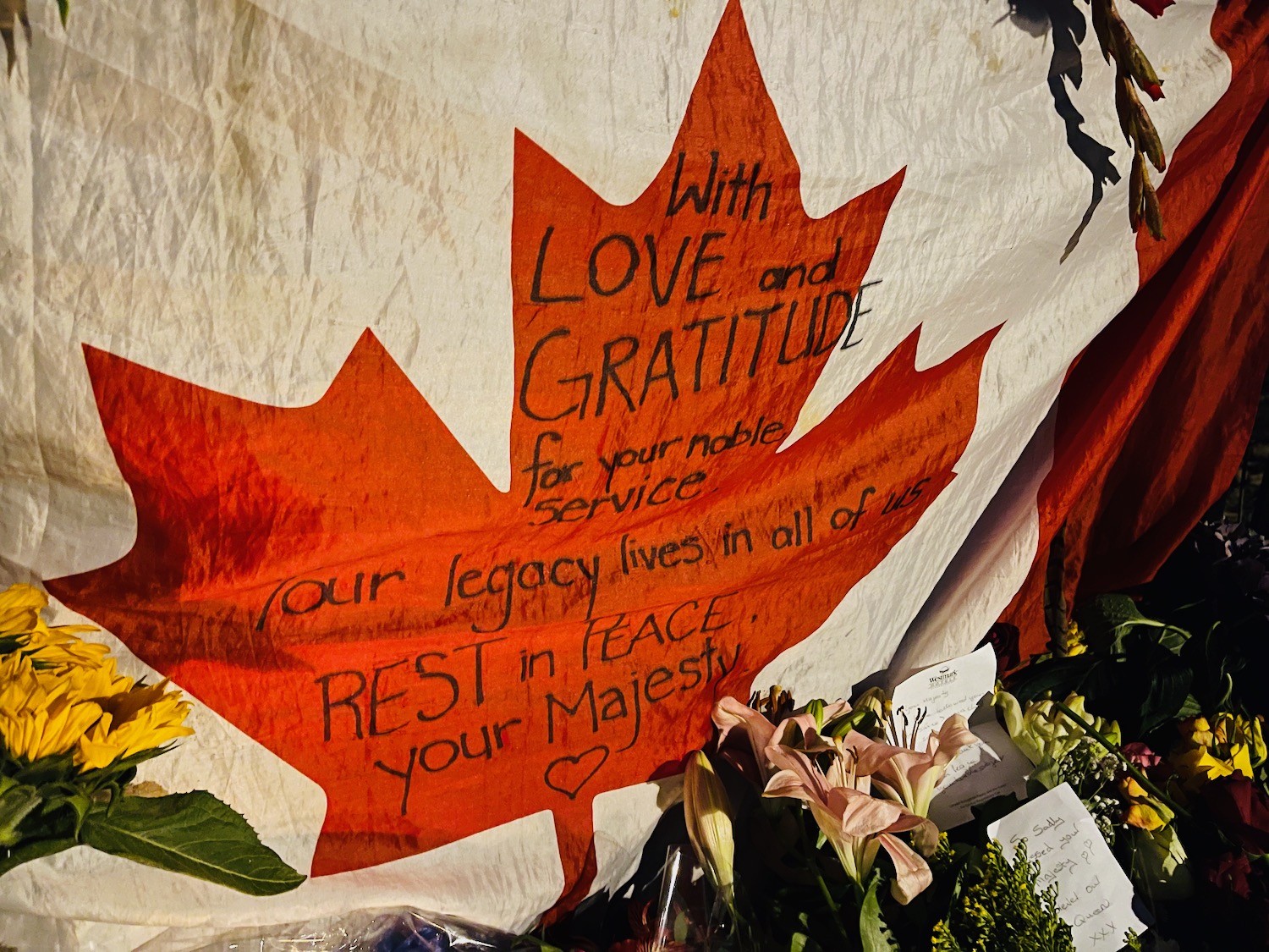 a flag with a maple leaf and flowers