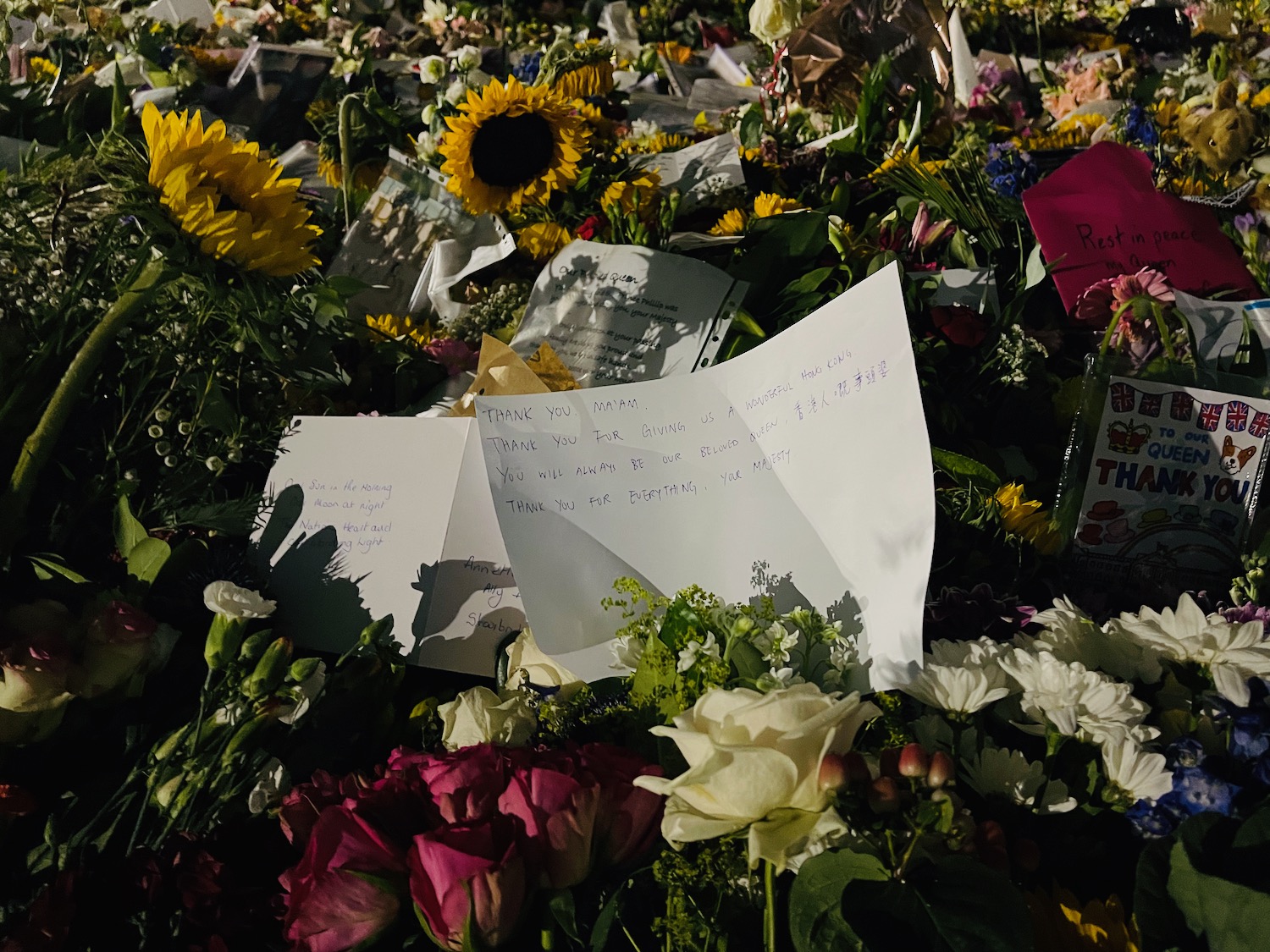 a pile of flowers with notes and cards