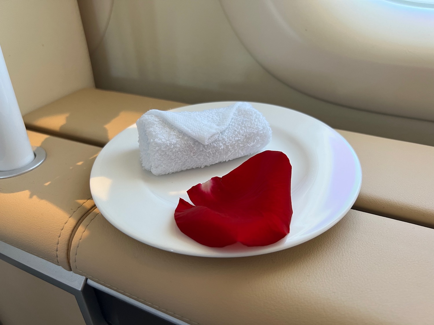 a plate with a towel and a rose petal on it