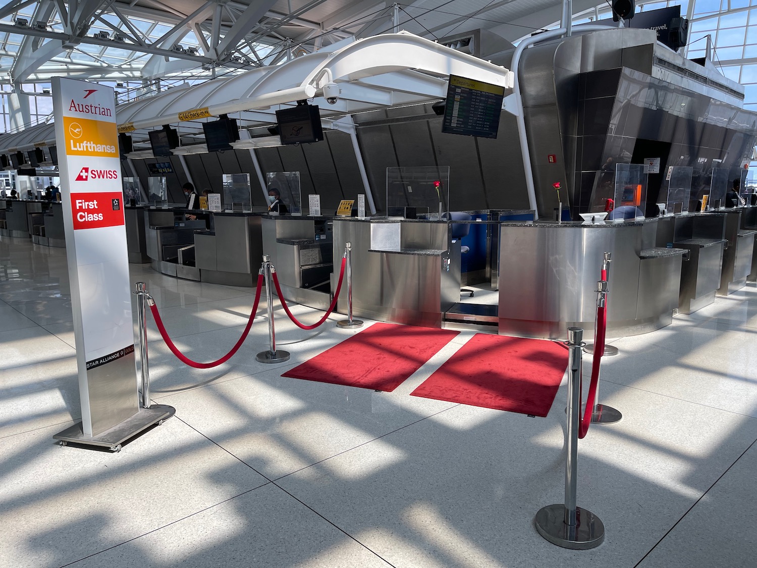 a red carpet and roped barriers in a airport