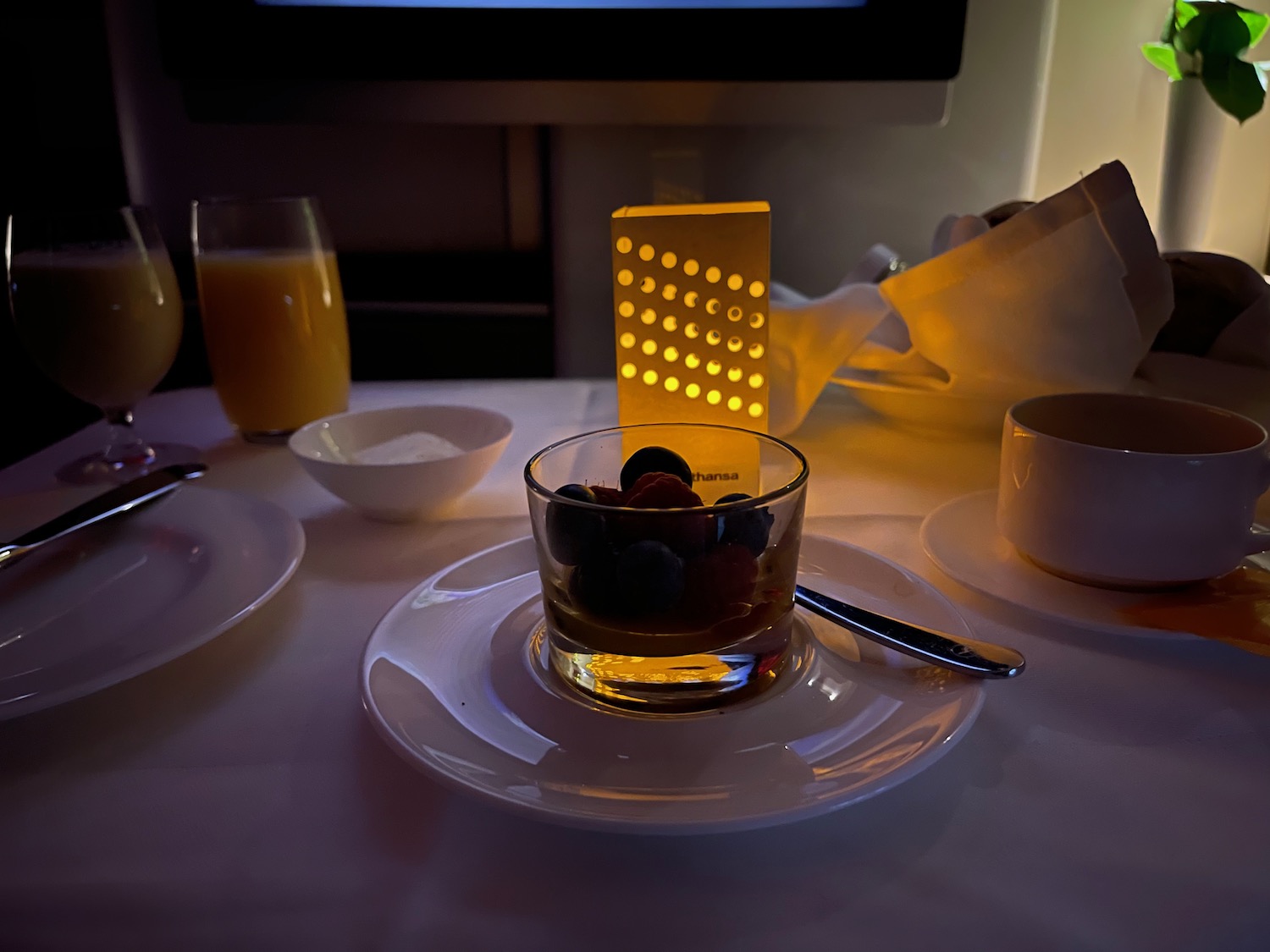 a table with a glass of fruit and a plate of juice