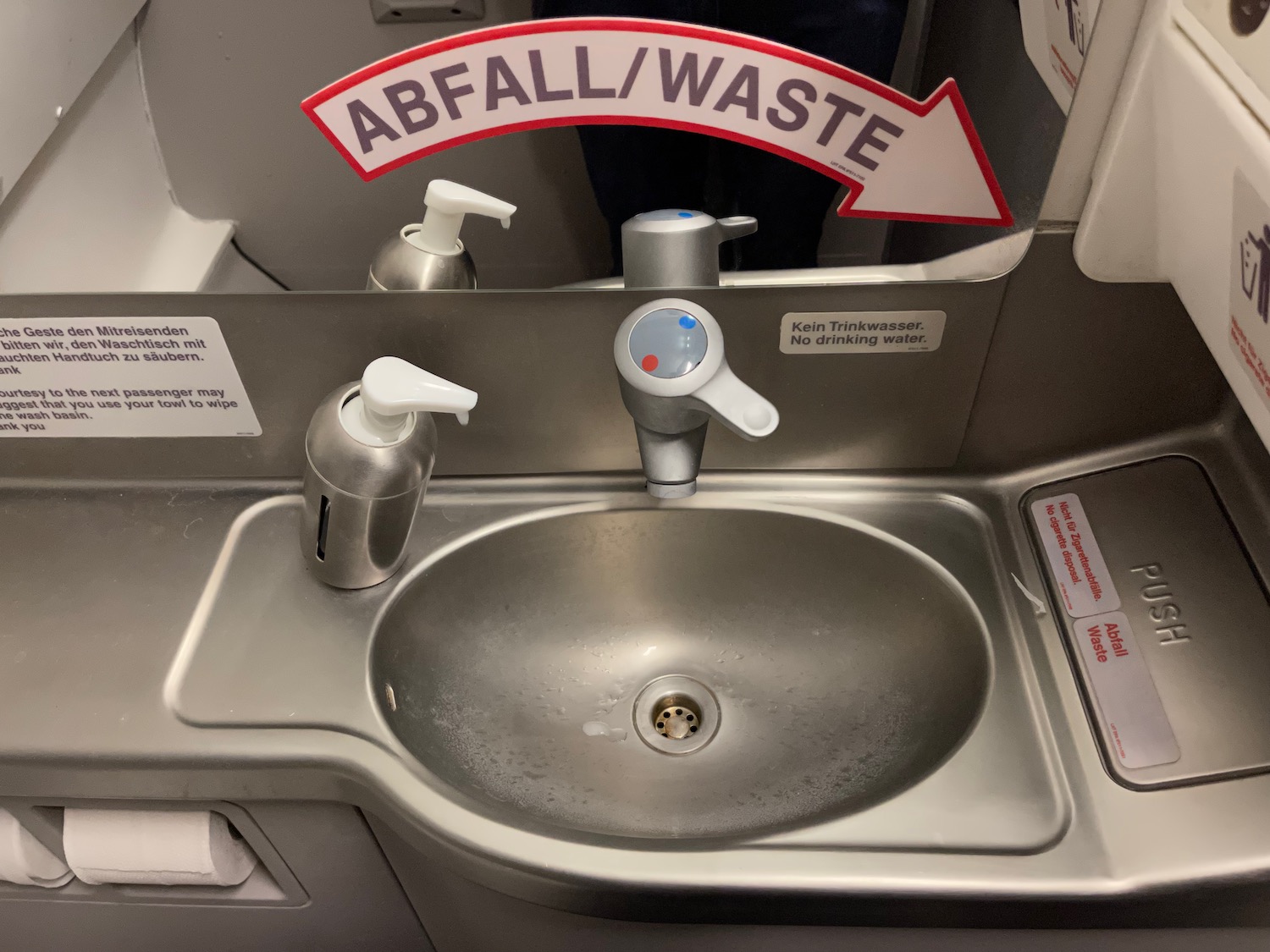 a sink with soap dispensers and a sign
