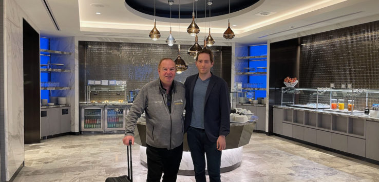 two men standing in a room with a luggage