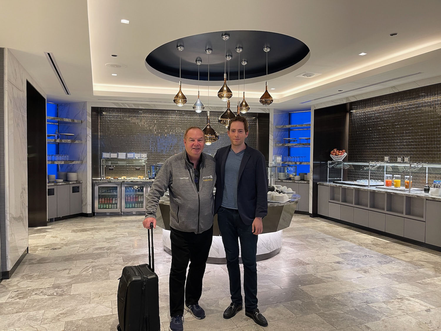 two men standing in a room with a luggage