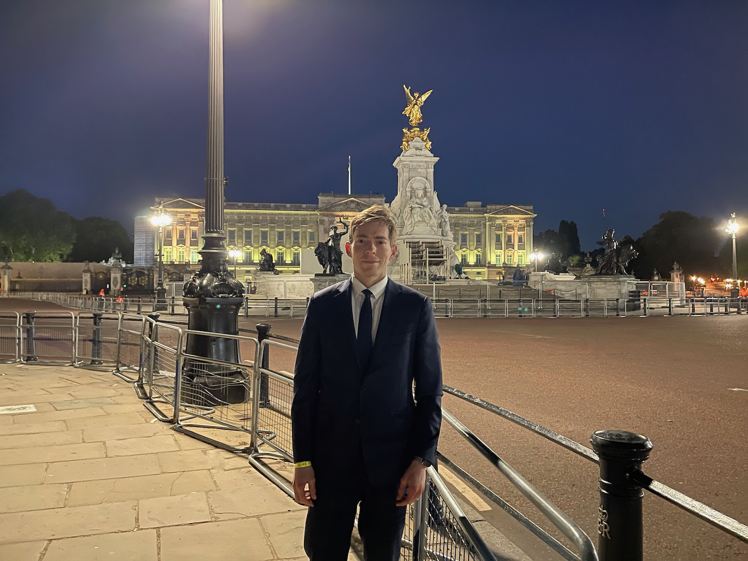 a man in a suit standing in front of a building