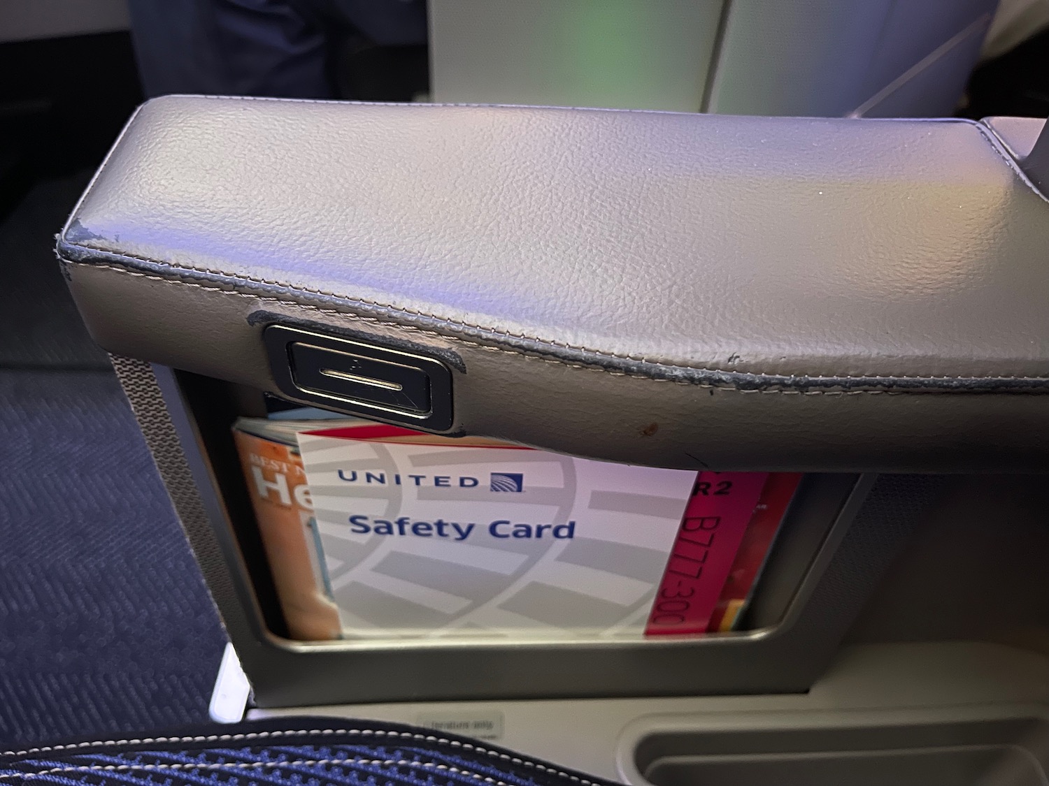 a seat arm rest with a safety card in it