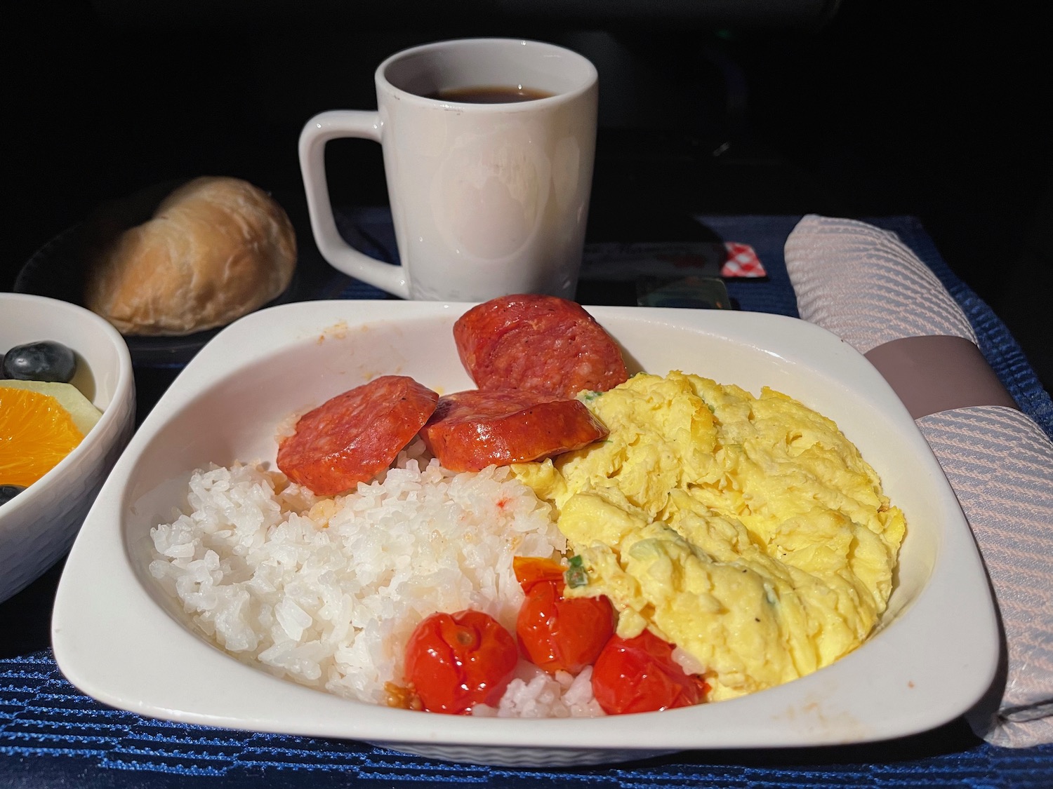 a plate of food with a cup of coffee and a napkin