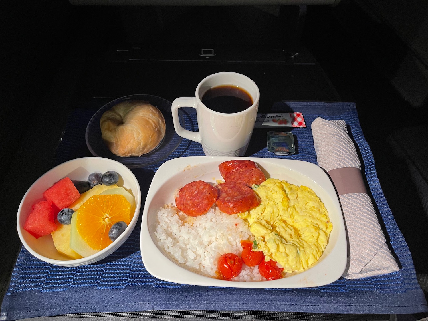 a plate of food and a cup of coffee on a blue place mat