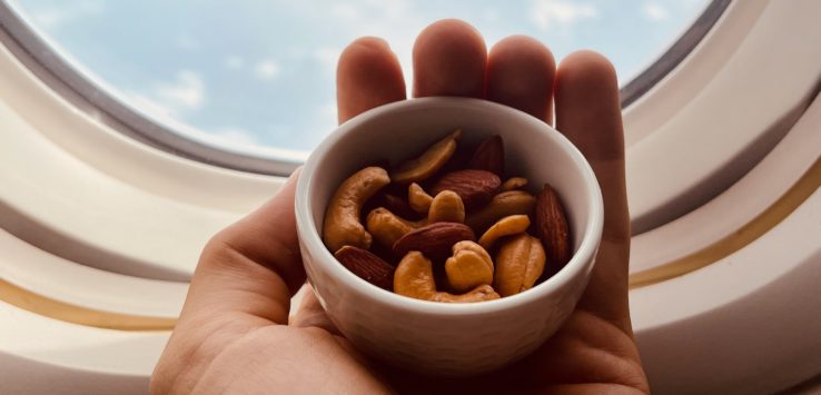 a hand holding a bowl of nuts