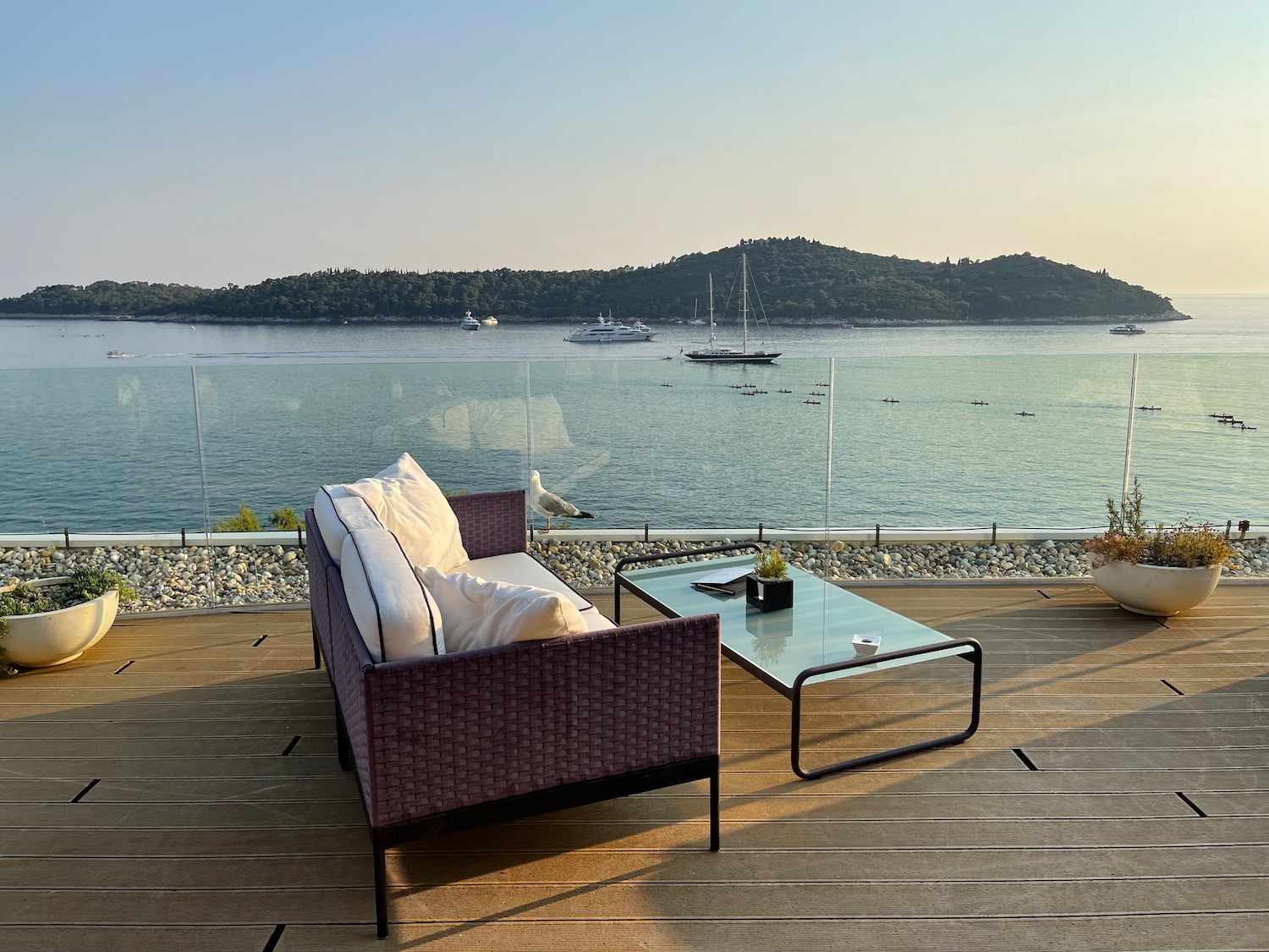 a couch and table on a deck overlooking a body of water