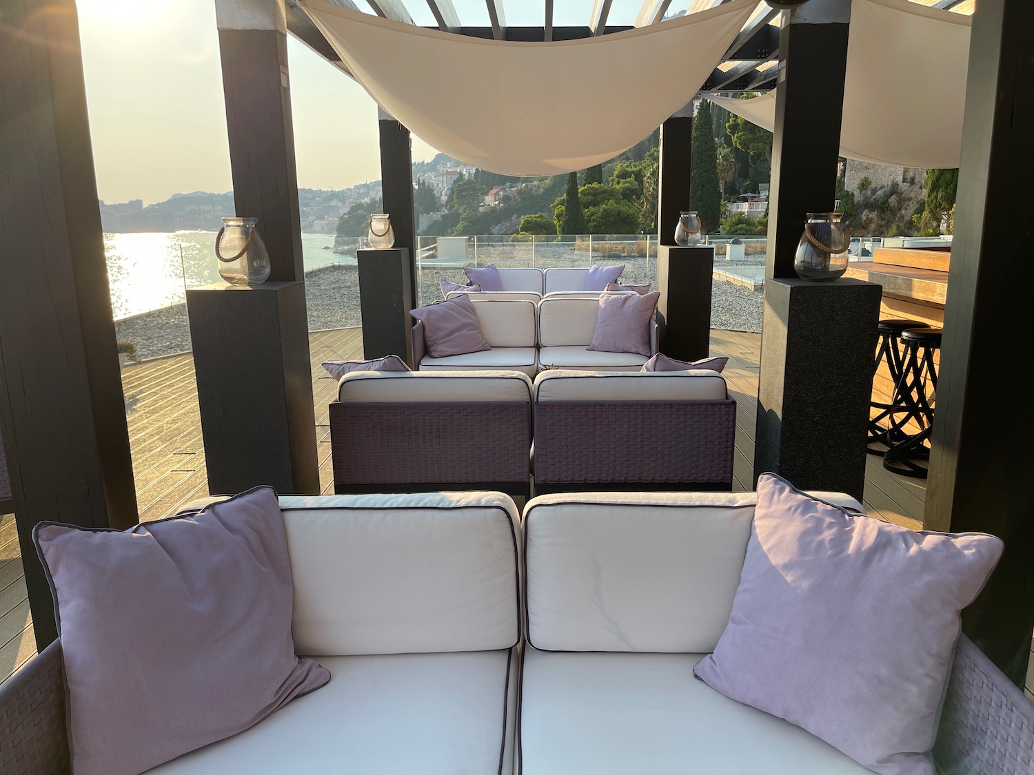 a patio with a white couch and purple pillows