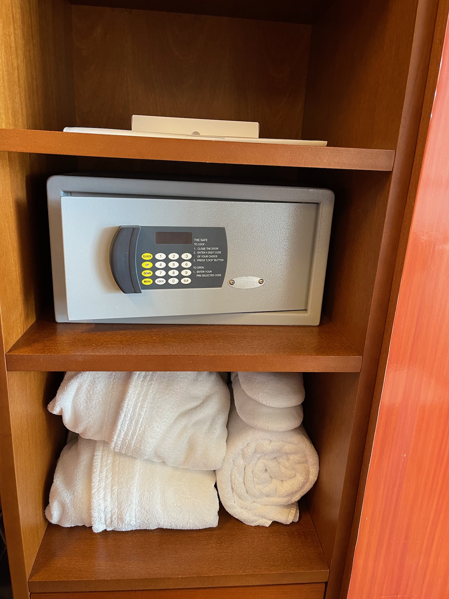 a safe and towels on a shelf