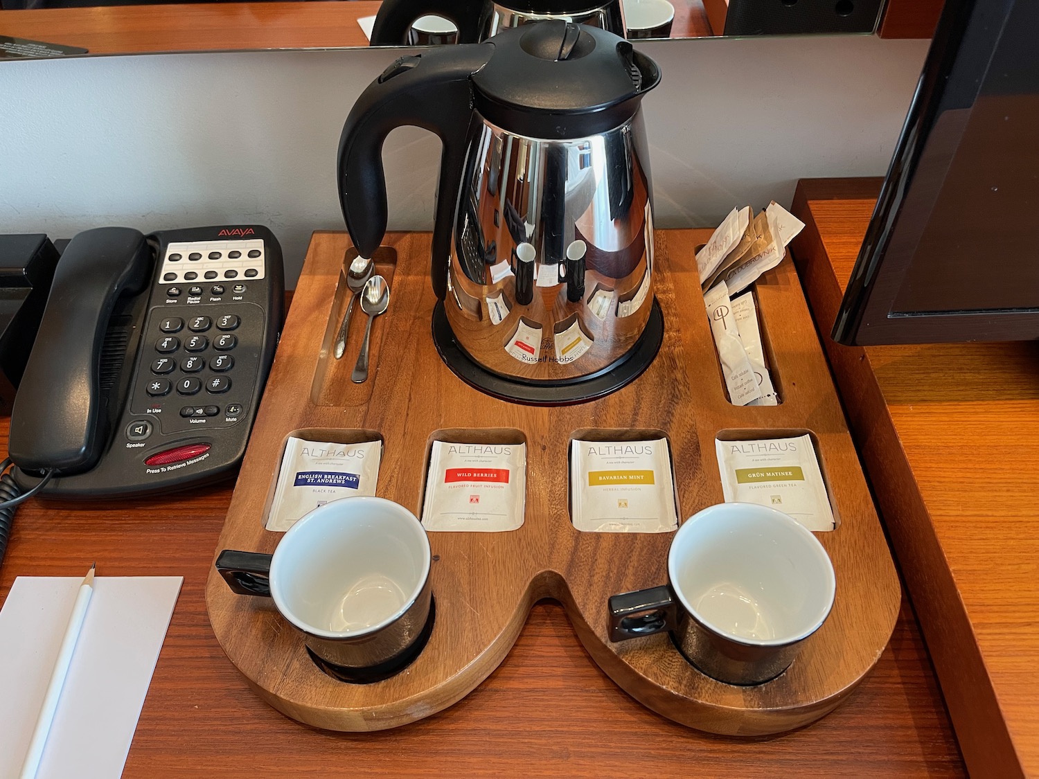 a coffee pot and cups on a wood tray