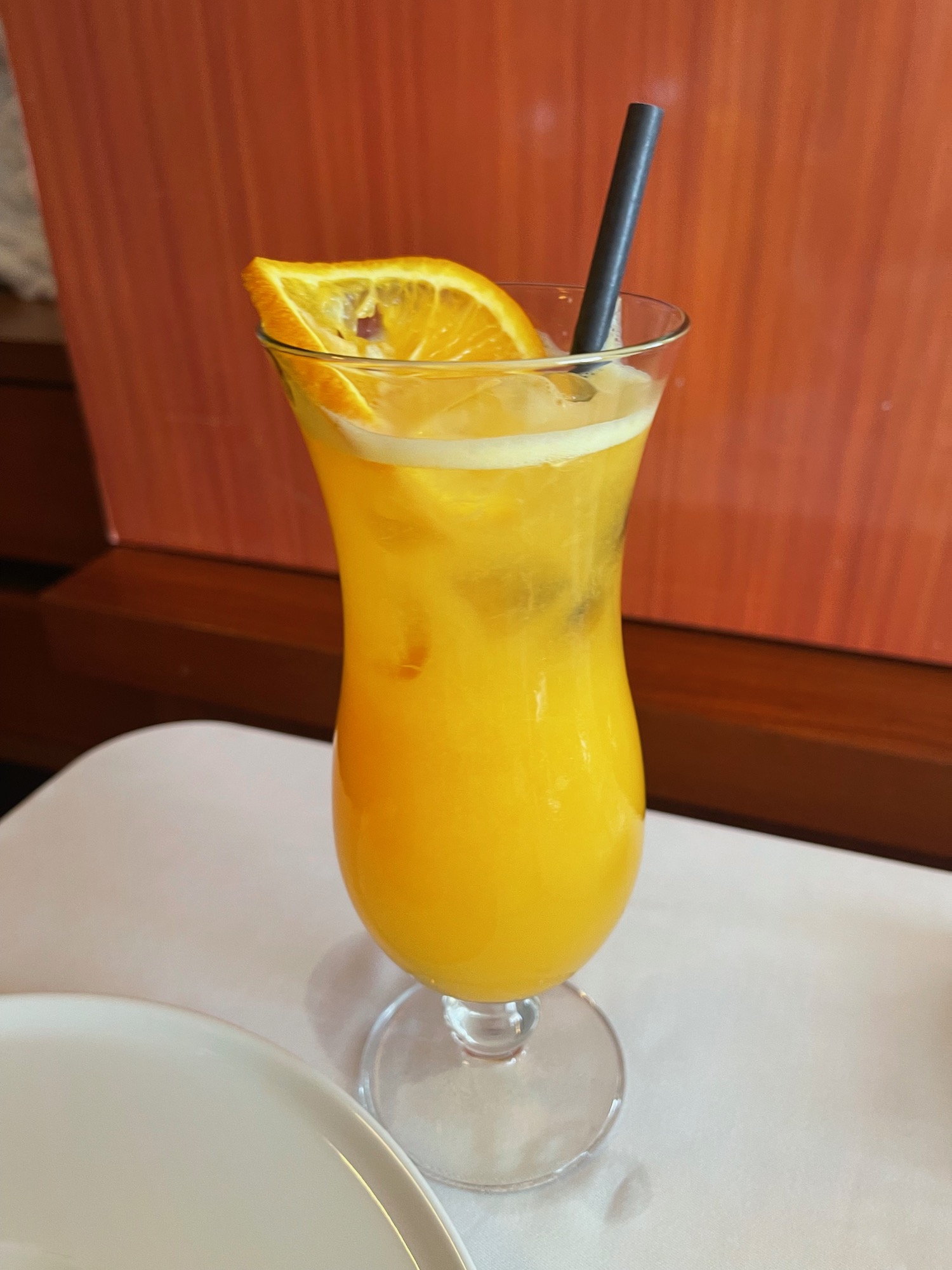 a glass of orange juice with a straw