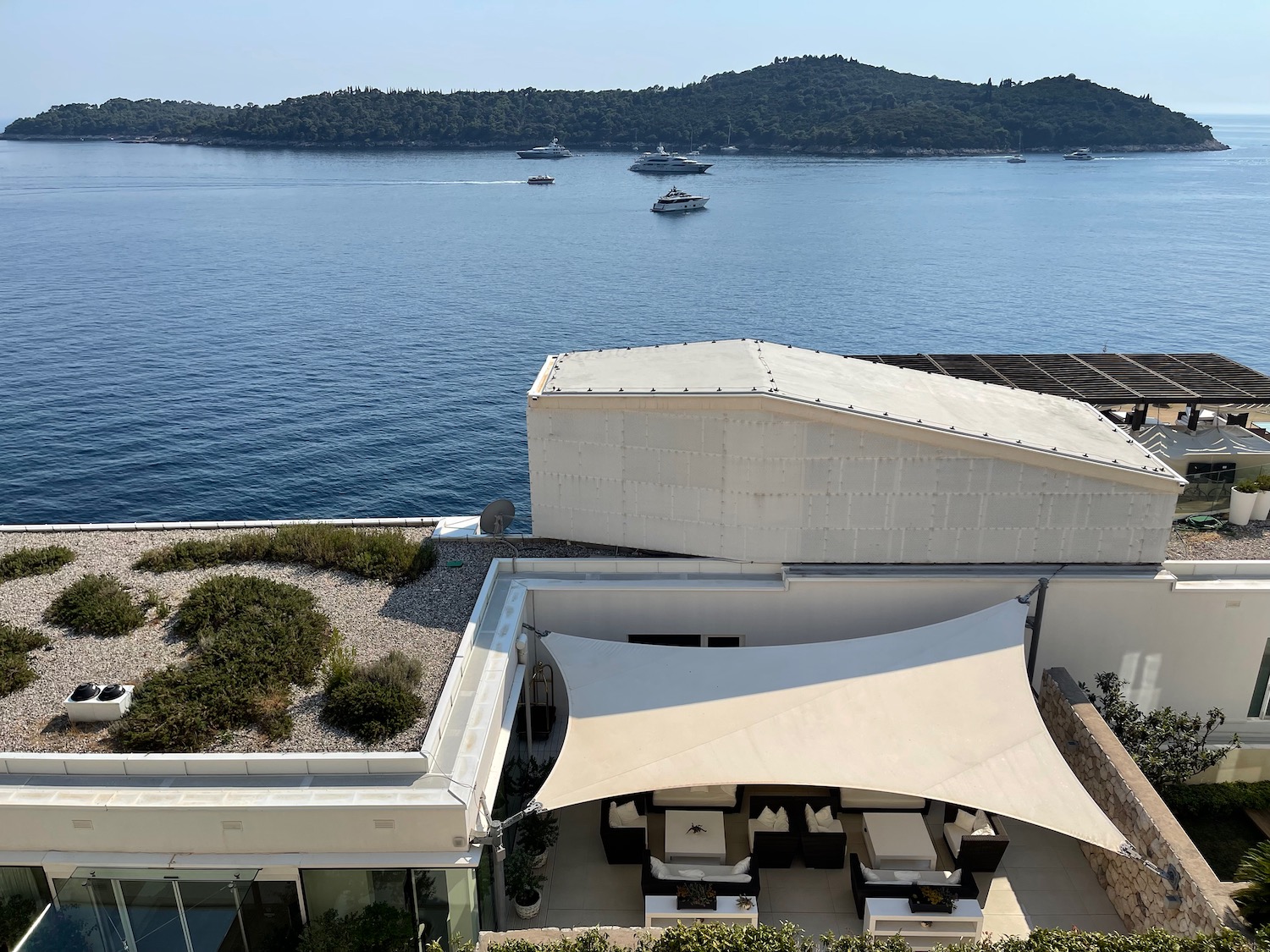 a building with a large body of water and boats in the background