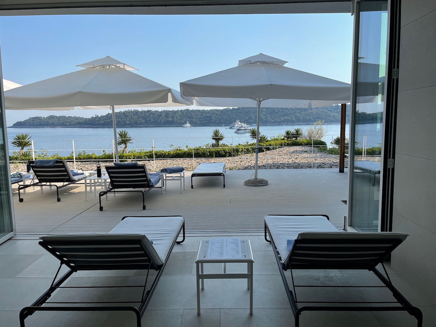 a deck with chairs and umbrellas overlooking a body of water