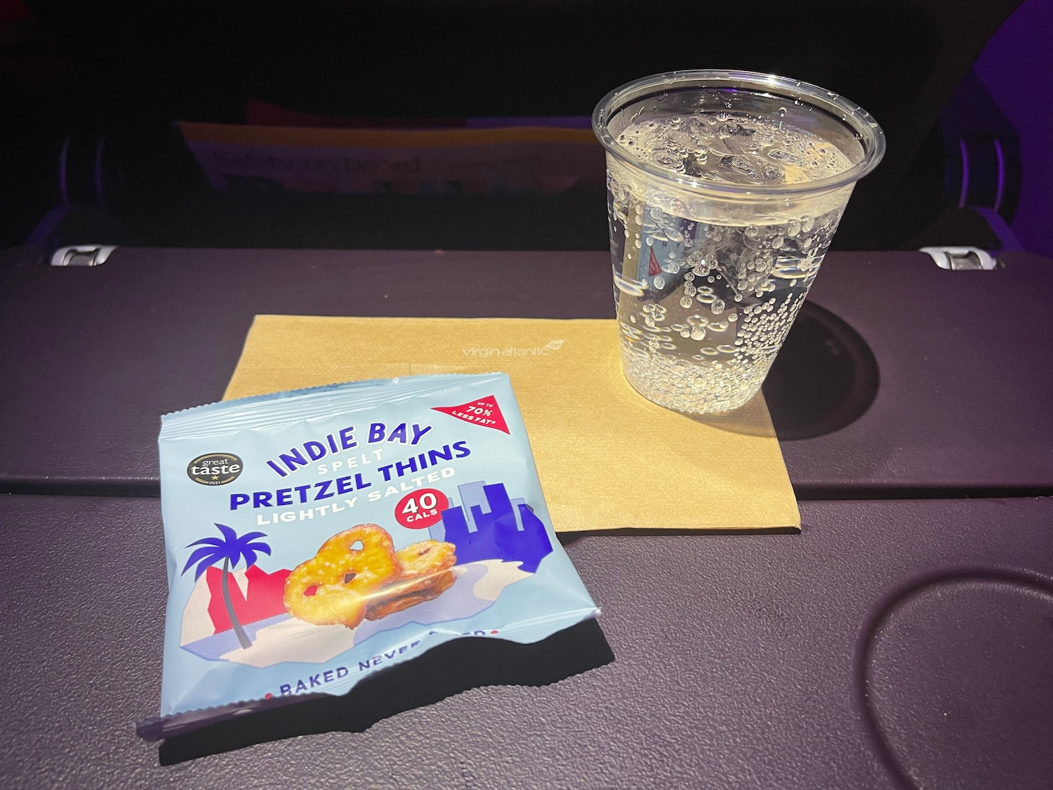 a plastic cup with a drink and a package of food on a table