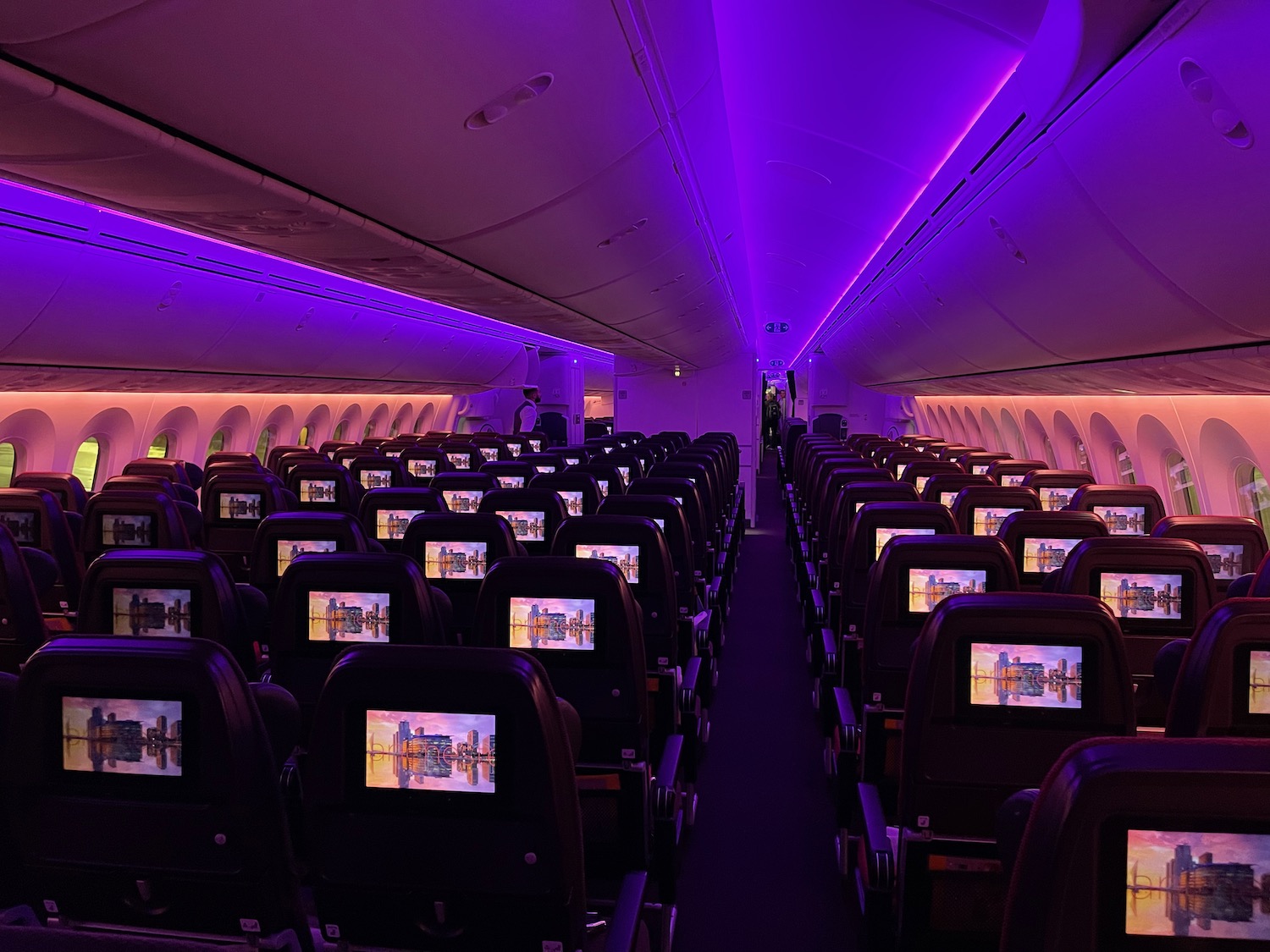 an airplane with rows of seats and purple lights