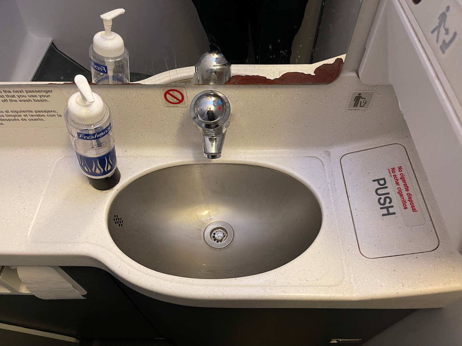 a sink with soap dispenser and bottle of liquid