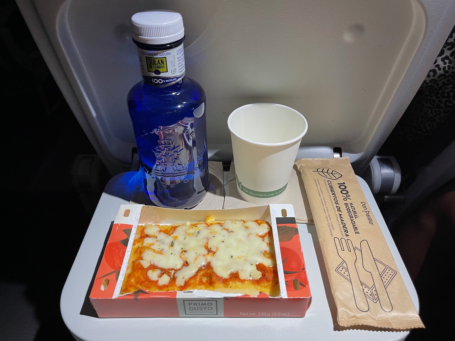 food on a tray with a drink and a bottle