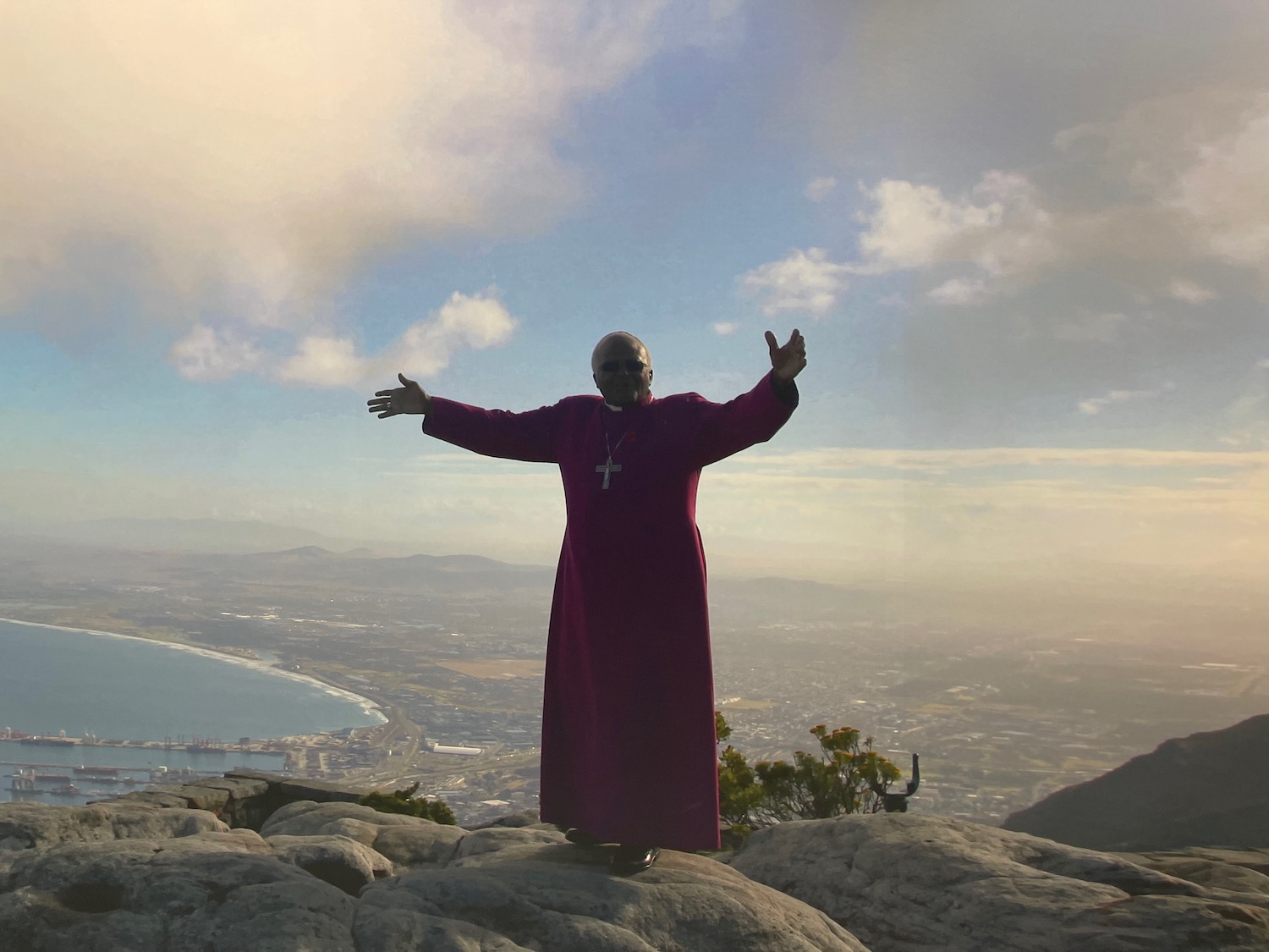 a man standing on a rock with his arms out