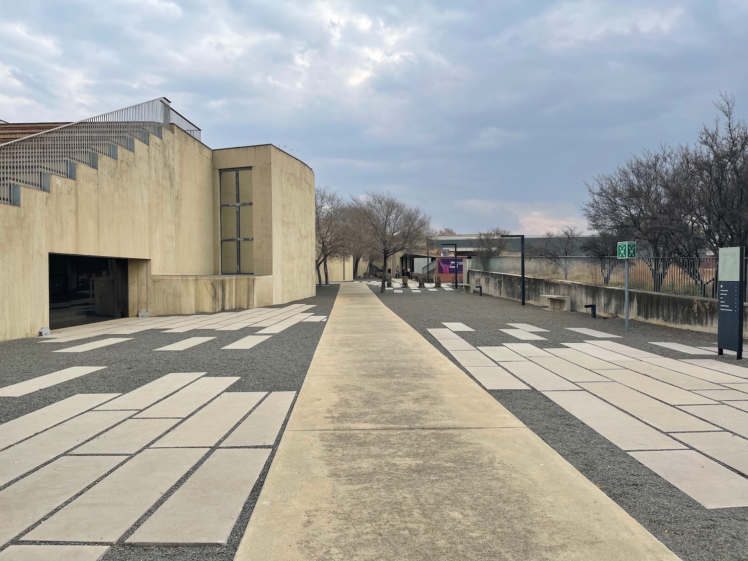 a walkway with a building and trees