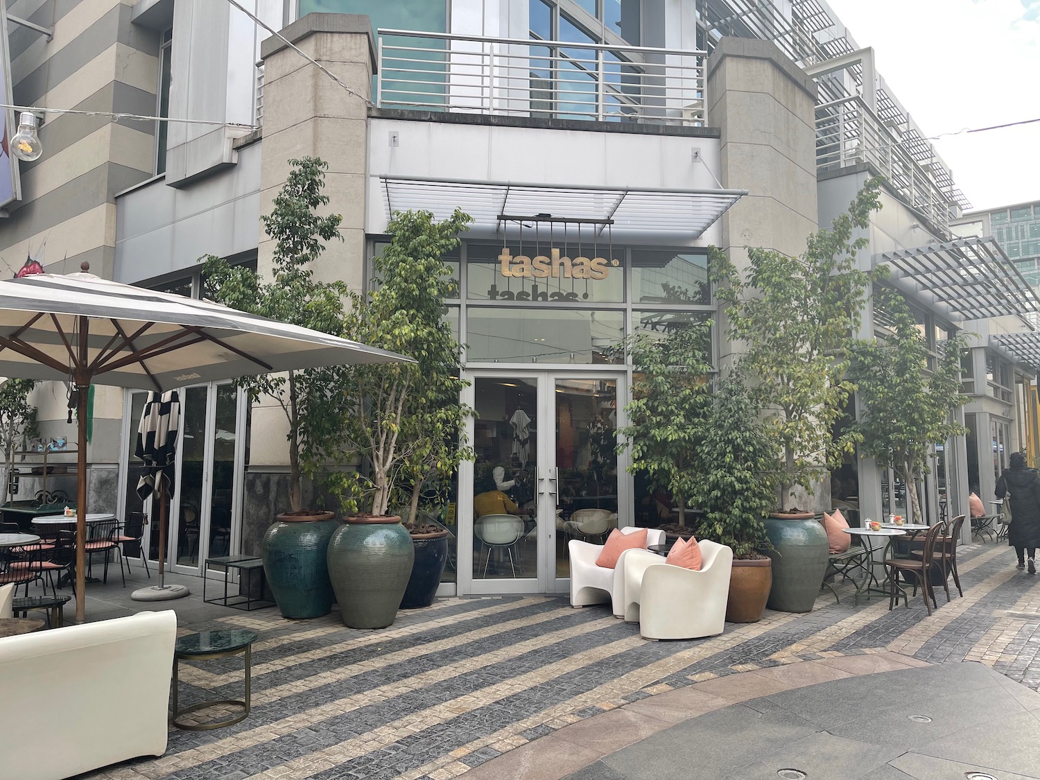 a store front with chairs and umbrellas