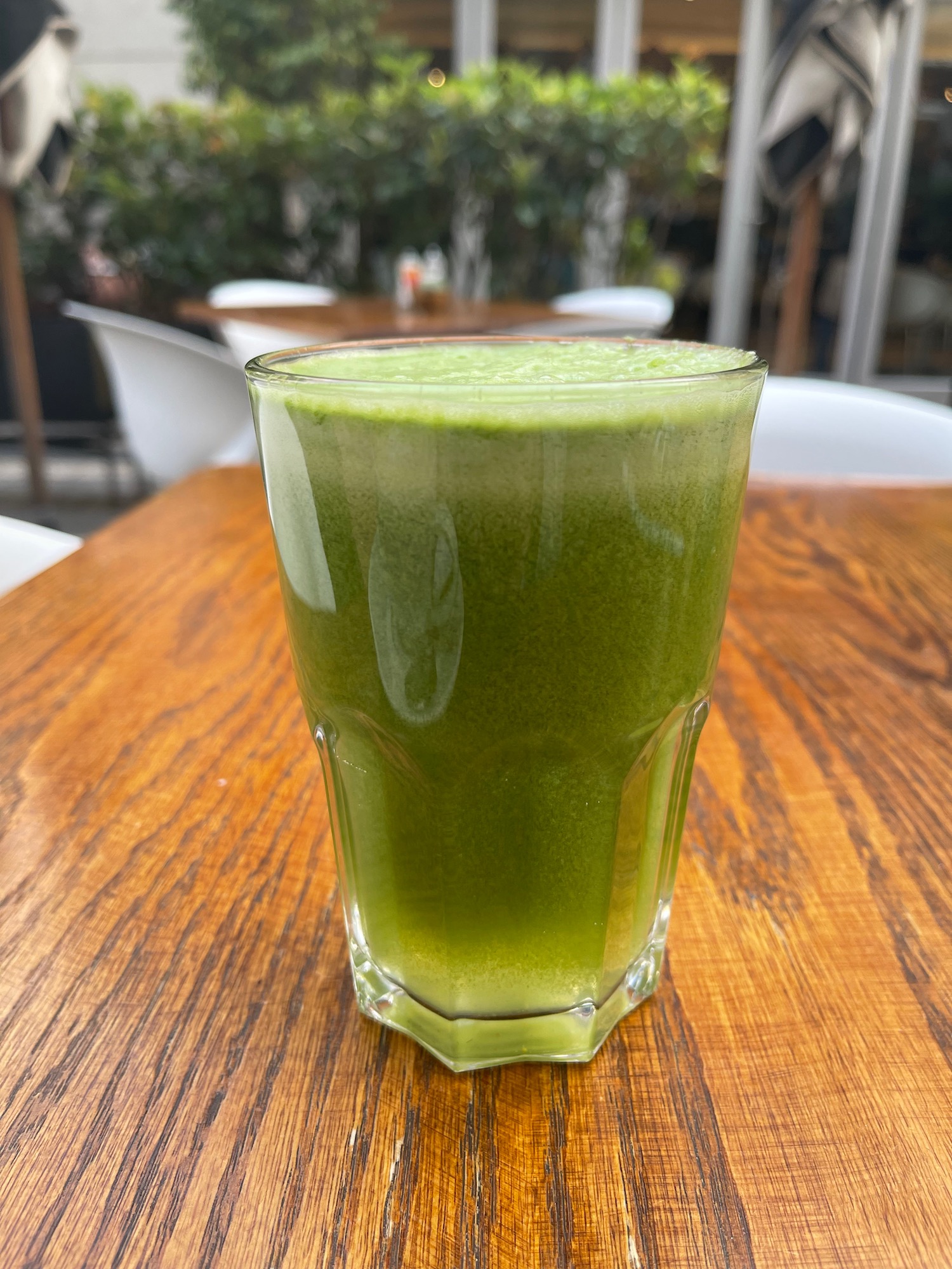 a glass of green liquid on a table