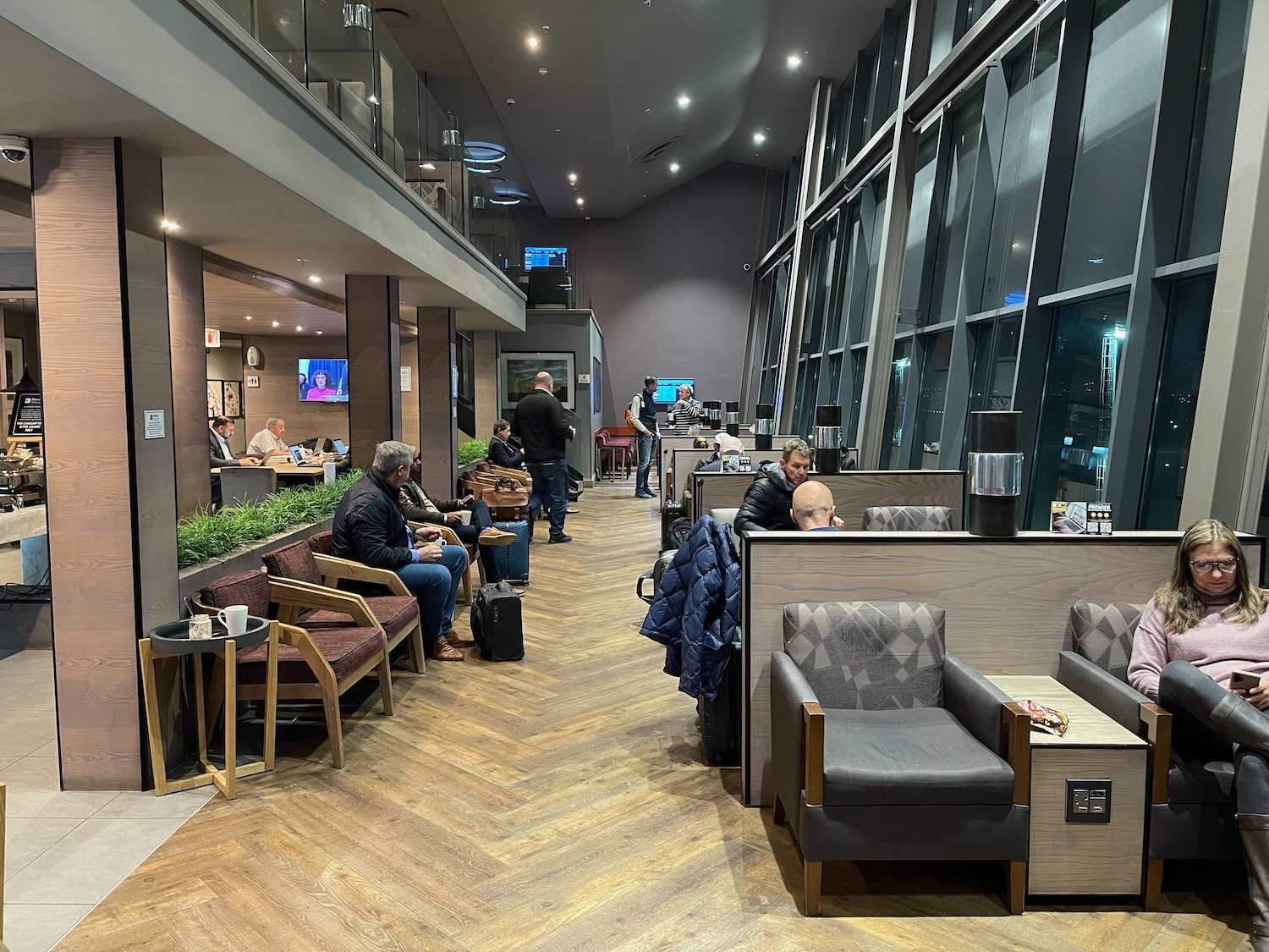 people sitting in a room with large windows