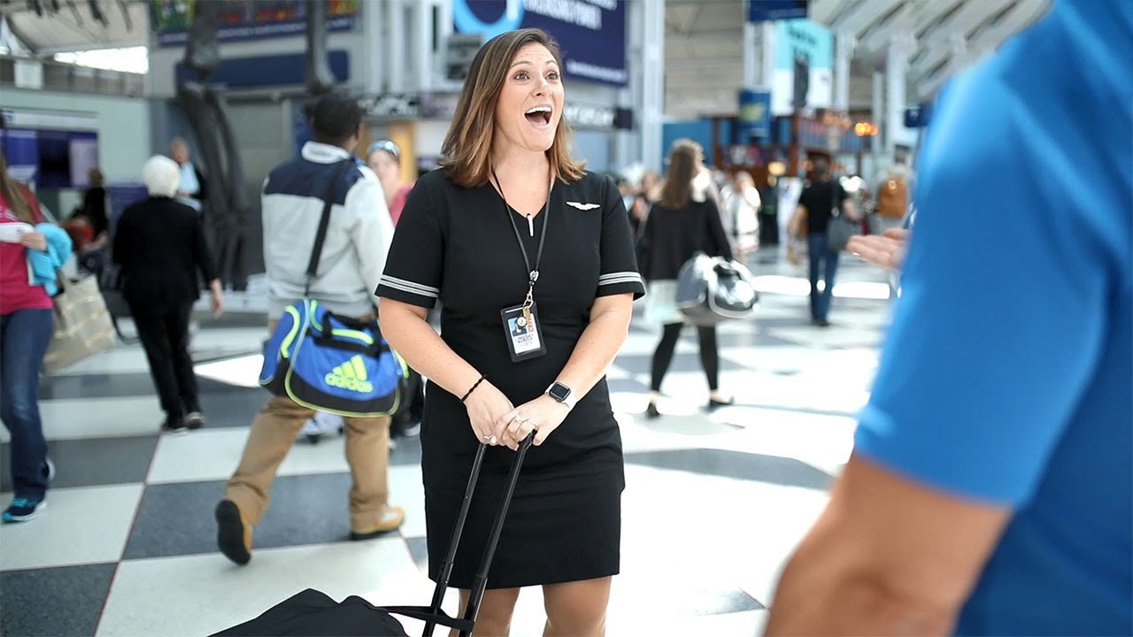 a woman in a black dress with luggage in a terminal