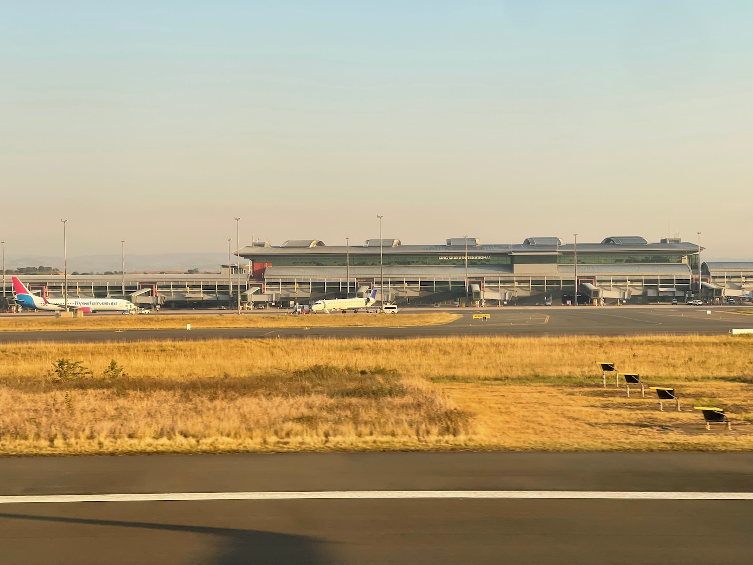 a runway with airplanes in the background