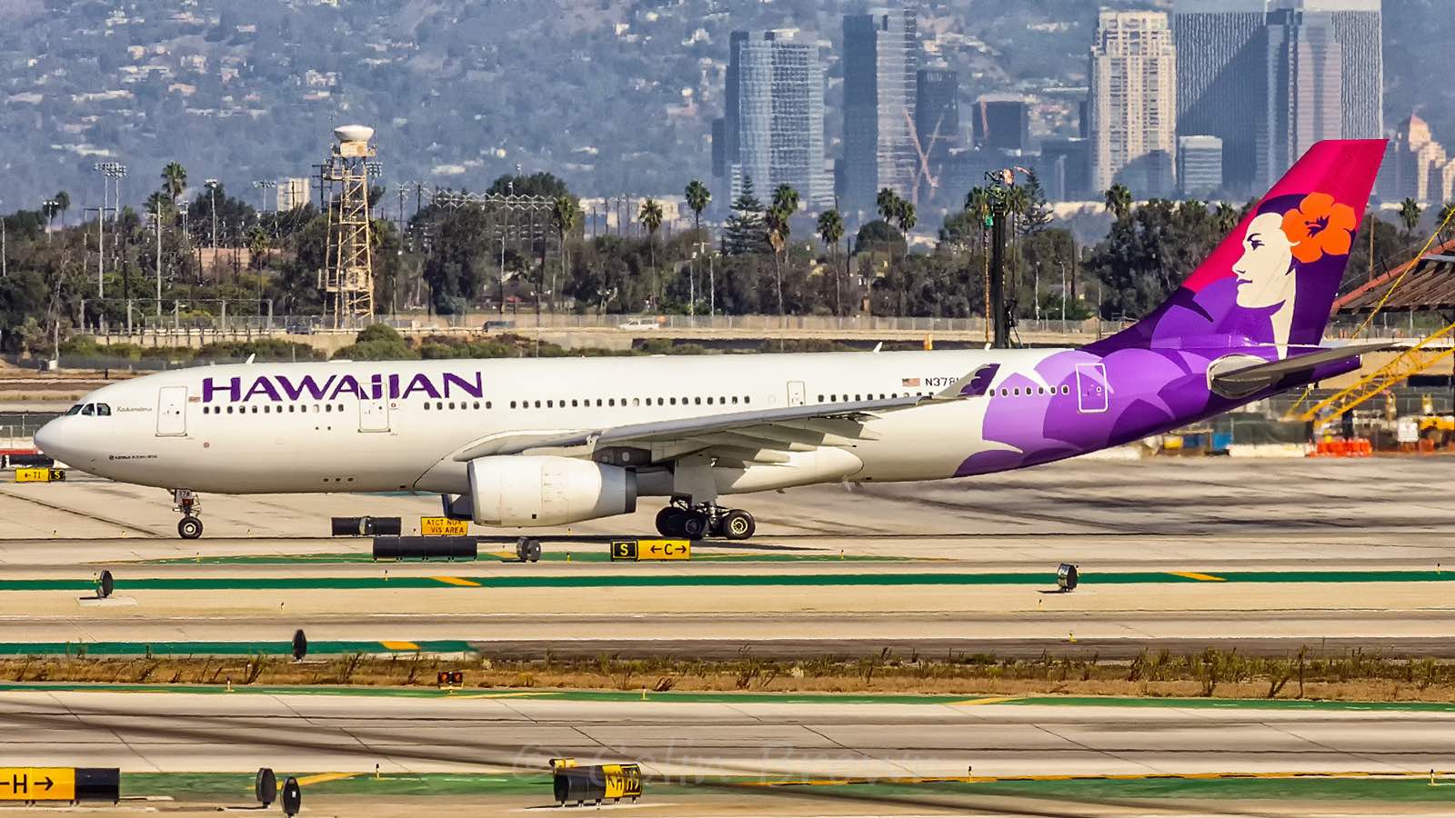 a large white and purple airplane on a runway