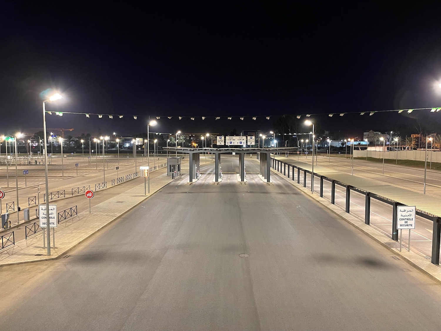 a road with a gate and lights at night