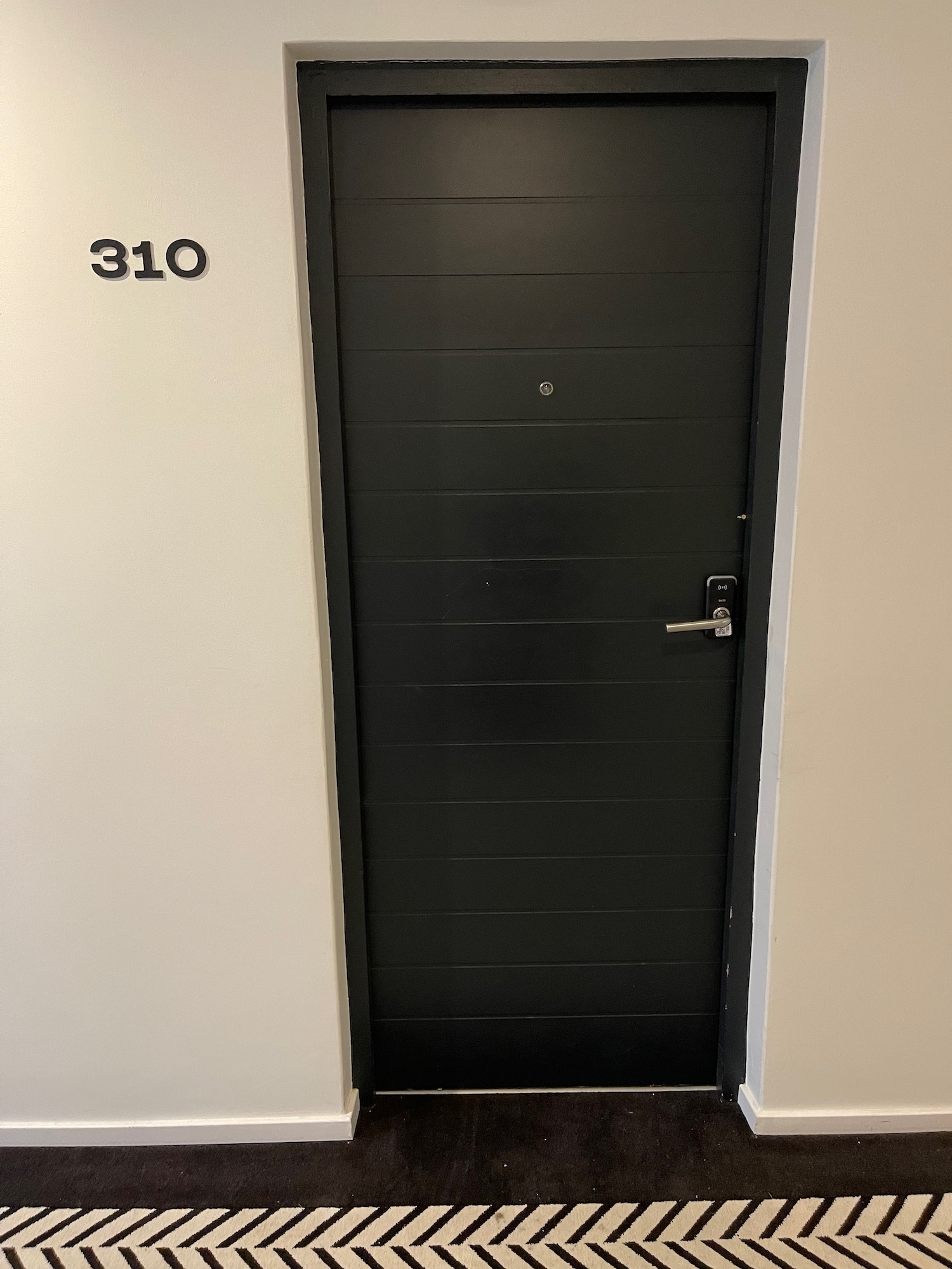 a black door with a number on the wall