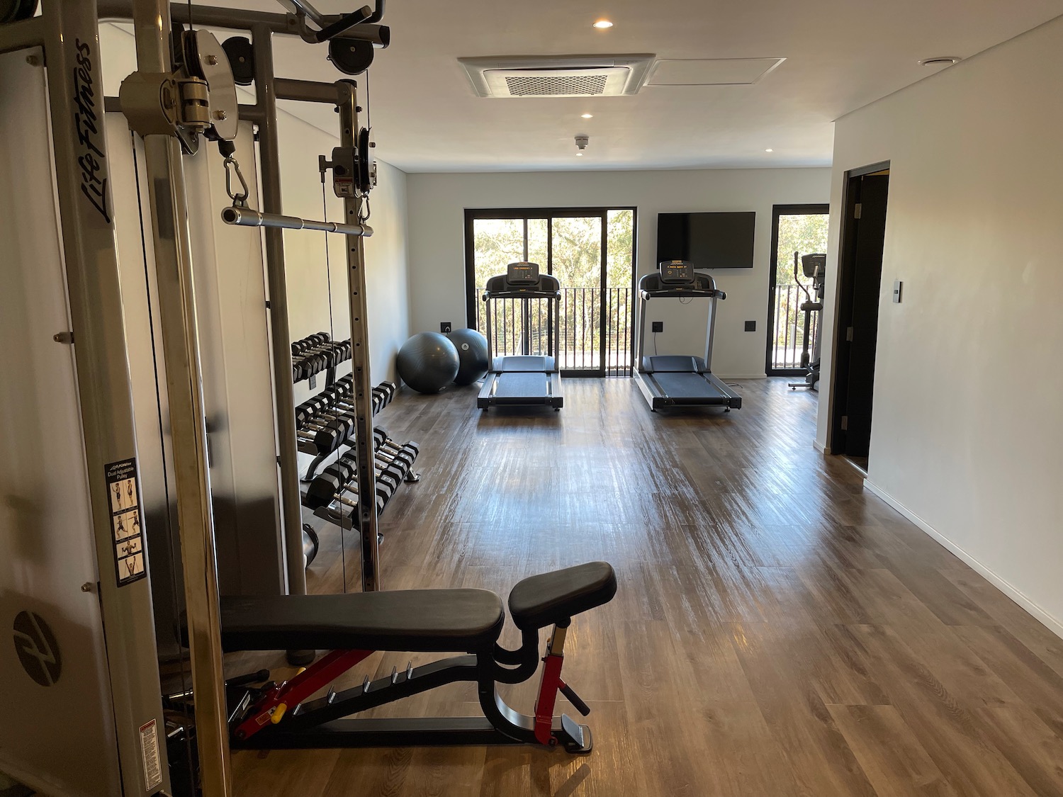 a room with exercise equipment and a door to the balcony