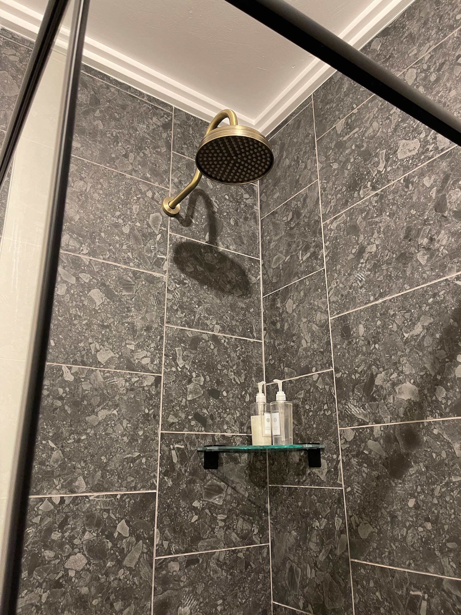 a shower head with soaps on a shelf